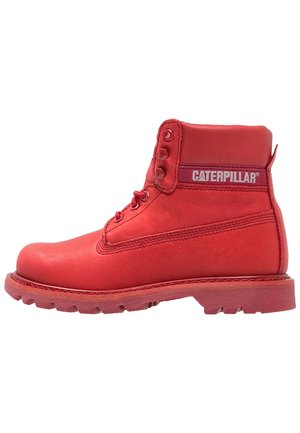 Czerwony but roboczy Caterpillar z przodem na sznurowadła, wyściełanym kołnierzem i wytrzymałą podeszwą zaprojektowaną z myślą o trwałości i wsparciu.