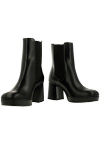 Svarta läderankelstövlar med elastiska sidor, rund tå och hög klack i staplad design. Slät yta med sömdetaljer.
