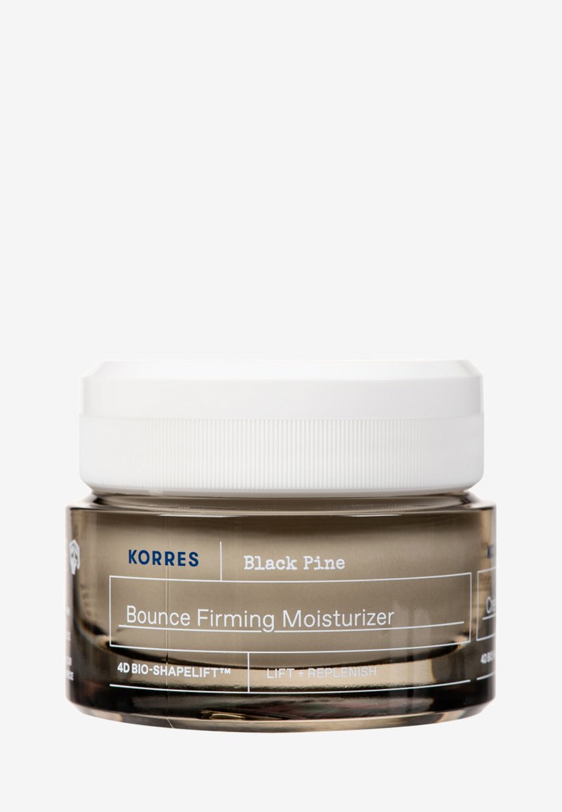 Korres Black Pine Bounce Firming Moisturizer i en transparent glasburk med ett vitt skruvlock, med blå och vita textetiketter.