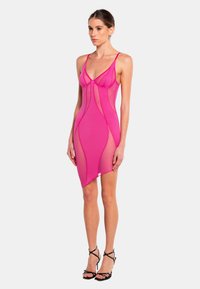 Fuchsia-pink Kleid mit figurbetontem Schnitt, transparenten Abschnitten und verstellbaren Trägern, das ein nahtloses Design und einen asymmetrischen Saum aufweist.