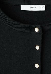 Cardigan nero a maglia con colletto a costine, dotato di tre bottoni perlacei con dettagli dorati e un'etichetta che indica la taglia e il marchio.
