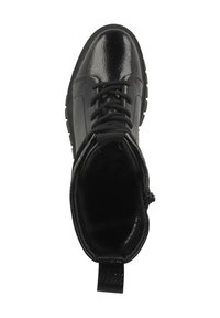 Botín negro de tobillo hecho de material sintético brillante. Presenta puntera redonda, parte frontal con cordones y una tira de agarre. Parte superior texturizada y suela de goma.