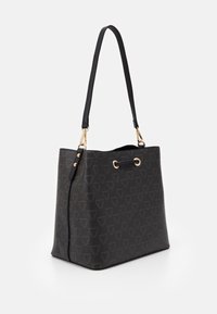 Black bucket bag in textured material with geometric logo pattern. Features a single adjustable strap, gold hardware, and a spacious design.