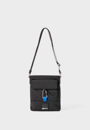 Must musträkikott, millel on reguleeritav rihm, esi flop, metallklamber ja sinine aksent. Omab logopatchi alumises osas.