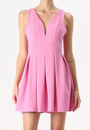 Robe sans manches rose avec un décolleté en V profond et une jupe plissée. Fabriquée à partir d'un tissu lisse, elle présente un corsage ajusté et un ourlet évasé.