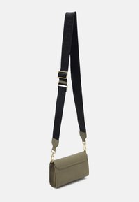 Olivgrön läder crossbody-väska med klaffstängning, som har en svart justerbar rem med präglad logotyp och detaljer i guldton.
