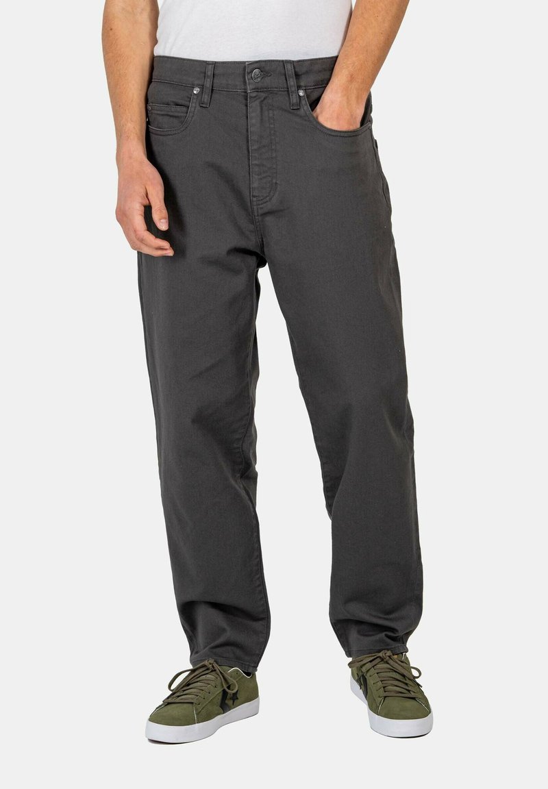 Dark gray straight-fit pants with a smooth texture, featuring front pockets and a button closure, paired with green sneakers.