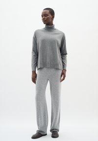 Gray knit turtleneck sweater with long sleeves, paired with matching gray knit wide-leg pants. Soft texture, relaxed fit. Brown footwear included.