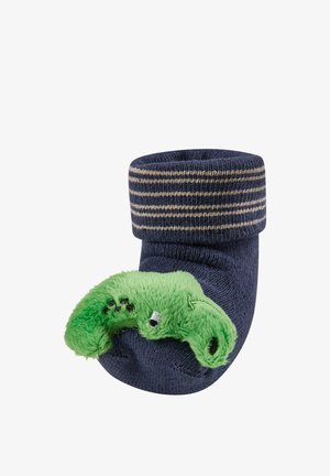 Navy baby sock with beige stripes on cuff and green plush caterpillar attached to toe.