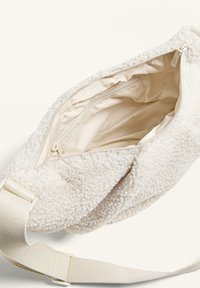 Borsa a spalla color crema realizzata in morbido pile testurizzato. Presenta una chiusura con cerniera e una tasca interna con fodera liscia.