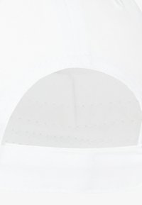 Interior de una gorra de béisbol blanca con una textura suave, que presenta costuras y agujeros de ventilación, mostrando un diseño limpio y sencillo.