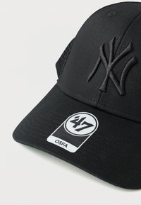 Czarna czapka z podniesionym logo Nowego Jorku, płaskim daszkiem i teksturowaną tkaniną. Posiada metkę z oznaczeniami '47' i 'OSFA'.