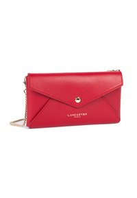 Pochette en cuir rouge de style enveloppe avec bouton-pression doré, logo "Lancaster Paris" doré et bandoulière chaîne dorée sur fond blanc.