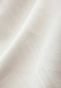 Țesătură albă cu o textură netedă, având un luciu subtire și detalii fine, cu un model ușor țesut, reflectând o lumină blândă.