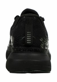 Svart atletisk sko med en texturerad ovandel, gummisulor, vadderad krage och en framträdande "UNDER ARMOUR"-logotyp på hälområdet.