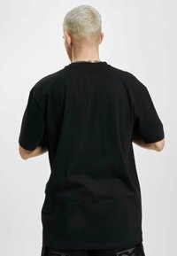 Sort kortærmet t-shirt, lavet af bomuldsstof, med en afslappet pasform og rund hals. Glat tekstur uden synlige mønstre.