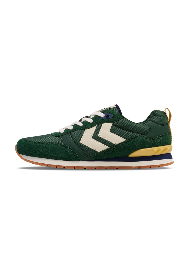 Green sneaker with white chevron accents, featuring a suede and mesh upper, white laces, and a rubber sole with a gum outsole.