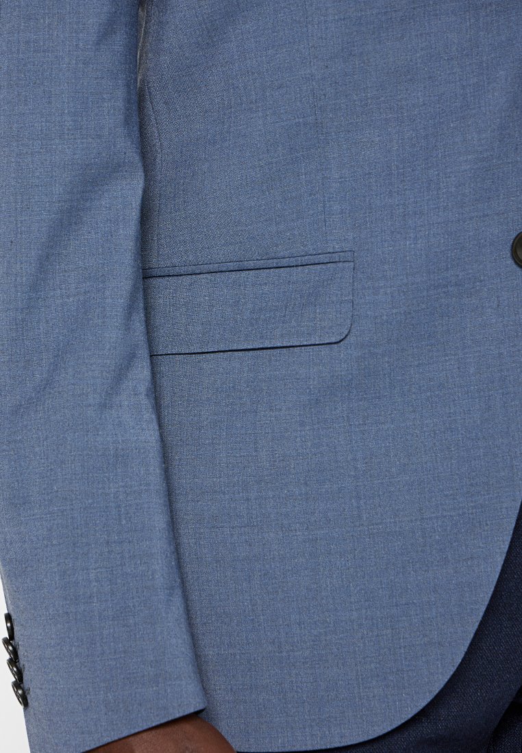 Hellblaues Blazergewebe mit strukturierter Oberfläche. Verfügt über eine einzelne Tasche und schwarze Knopfdetails an den Manschetten.