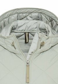 Lys grå quilted pufferjakke med hætte, med en frontzipper og to lynlåslommer på siderne. Glat, skinnende stofstruktur.