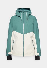 Teal- och gräddfärgad skidjacka med dragkedja framtill, justerbar huva, fickor med dragkedja och elastiska ärmslut. Slät textur, hållbart tyg.