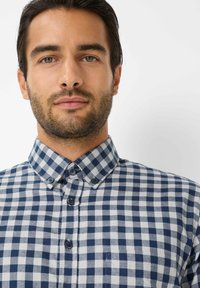 Blauw-wit geruiten shirt met een klassieke button-down kraag, zichtbare knopen en een textuur van katoen.