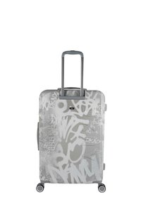 Maleta rígida con acabado mate plateado, cubierta de patrones en estilo graffiti blanco. Cuenta con un asa retráctil y cuatro ruedas.