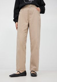 Pantaloni beige a vita alta con taglio dritto, realizzati in cotone resistente. Presentano passanti per cintura, tasche anteriori e chiusura con bottone.
