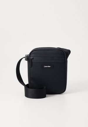 Borsa a tracolla nera in nylon strutturato con finitura liscia. Presenta una chiusura con zip, una tracolla regolabile e il dettaglio del logo del marchio.