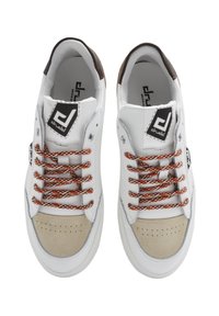 Sneaker bianche con punta in suede beige, lacci a fantasia arancione e bianca, colletto imbottito e etichetta nera prominente sulla linguetta.