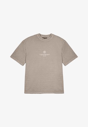 Veľká béžová bavlnená tričko s okrúhlym výstrihom, krátkymi rukávmi a bielym potlačeným textom na prednej strane. Má rovný lem a voľný strih.