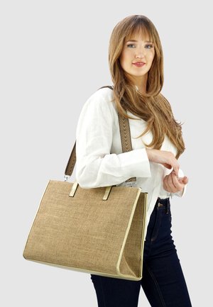 Geflochtene Tragetasche in Beige mit goldenen Akzenten und zwei oberen Griffen. Verfügt über einen gemusterten Schulterriemen und eine strukturierte Form.