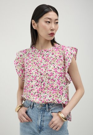 Top con stampa floreale nelle tonalità di rosa e beige, maniche a farfalla corte e scollatura arrotondata, abbinato a pantaloni corti di jeans a vita alta.