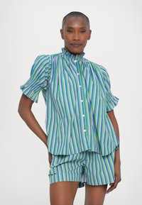 Camisa de manga corta a rayas con cuello alto en verde, azul y morado. Presenta botones en el frente y detalles de manga abullonada. Los pantalones cortos hacen juego.
