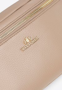 Beżowa skórzana saszetka z teksturowanym wykończeniem, złotym zamkiem błyskawicznym i wytłoczonym logo "WITTCHEN". Kompaktowy design do przenoszenia najpotrzebniejszych rzeczy.