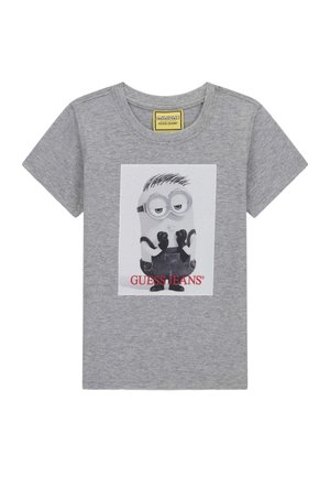 Siva majica kratkih rukava s likom Miniona koji nosi crne rukavice i tregerice, isprintana sprijeda s tekstom "GUESS JEANS" ispod.