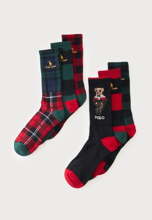 Six paires de chaussettes colorées à carreaux et à motifs en rouge, vert, noir et bleu marine, avec le logo Ralph Lauren et un motif d’ours.