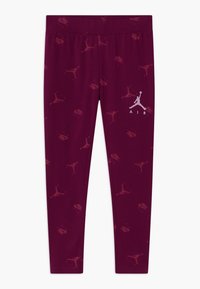 Bordowe legginsy z powtarzającym się wzorem logo oraz białym logo Air Jordan na lewej nodze, wykonane z elastycznego materiału.