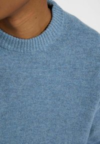 Blauer gestrickter Pullover mit einem gerippten Rundhals. Weiche Textur und ein leicht meliertes Muster. Das Material wirkt leicht und leger.