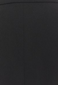 Jupe en tissu noir à texture lisse. Présente une coupe ajustée et un design épuré sans ornements, avec des coutures discrètes le long des coutures.