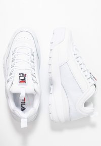 Le sneaker sportive bianche presentano una tomaia testurizzata con pannelli lisci e in suede, chiusura con lacci e una suola in gomma solida. Logo sulla linguetta.
