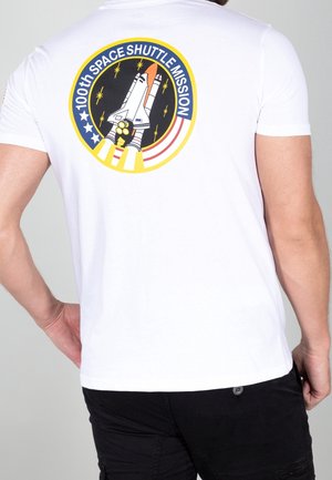 Weißes Baumwoll-T-Shirt mit bunter Grafik eines Space Shuttles und dem Text "100. SPACE SHUTTLE MISSION" auf der Rückseite. Kurze Ärmel.