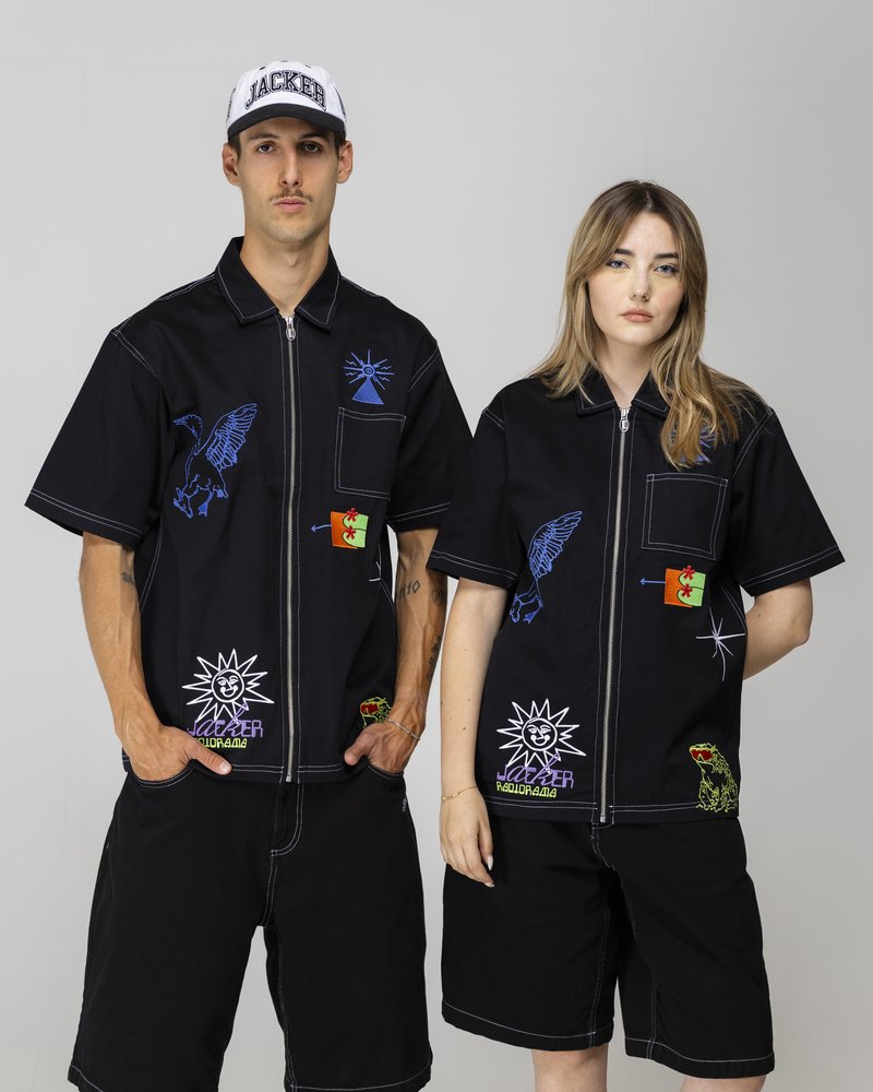 Black short-sleeve shirts with assorted colorful embroidered patches; features a zipper, two pockets, and dark shorts.