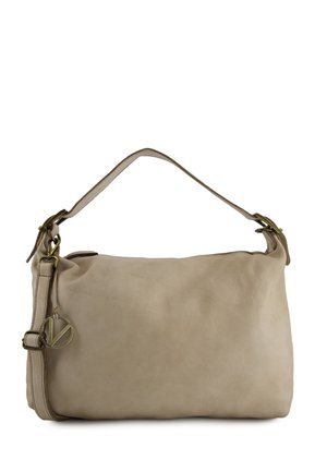 Beżowa skórzana torba na ramię z regulowanym paskiem i okrągłym metalowym zawieszkiem z logo wiszącym przy bocznej sprzączce.