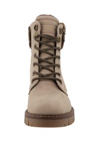 Bottines en daim beige avec lacets marron, œillets en métal et doublure en fourrure au col. Semelle en caoutchouc épais avec un motif cranté.