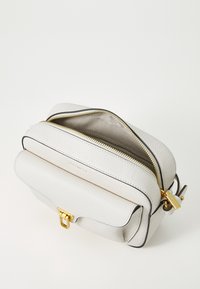 Borsa in pelle grigia chiara con finitura granellata e dettagli in oro, due scomparti con zip, una patta anteriore e bordi neri. Fodera interna liscia.