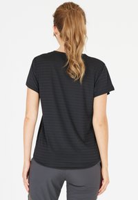 Sort atletisk t-shirt med korte ærmer, har subtile vandrette striber, blød tekstur og en afrundet kant, parret med grå shorts.