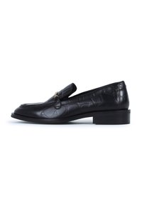 Black leather loafer with crocodile pattern, flat heel, rounded toe, and decorative leather tassel on the front. Smooth texture.