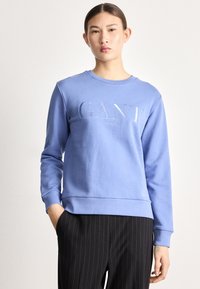 Felpa azzurro chiaro in misto cotone, con scollo rotondo e polsini a costine, con logo "GANT" ricamato in bianco.