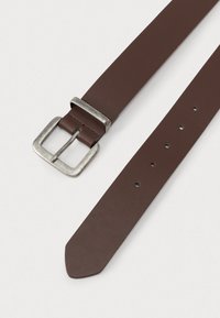 Pruun nahkrihm hõbedase ristkülikukujulise metallist pandlaga ja kuue reguleerimisauguga ühtlasel heledal taustal.