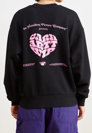 Schwarzer Sweatshirt mit pinkem Grafiktext auf der Rückseite, mit geripptem Saum und Bündchen. Lockerer Schnitt, aus weichem Material gefertigt.